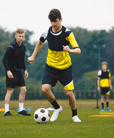 jeune garçon jouant au football durant un camp d'été